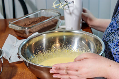 Midsection of woman having food in kitchen