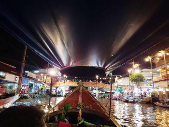 Illuminated bridge over canal in city at night