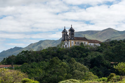 Tower amidst trees and buildings against sky