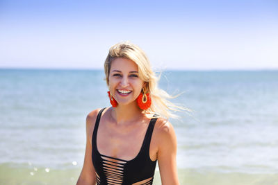 Portrait of smiling young woman against sea