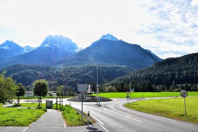 Road by mountains against sky