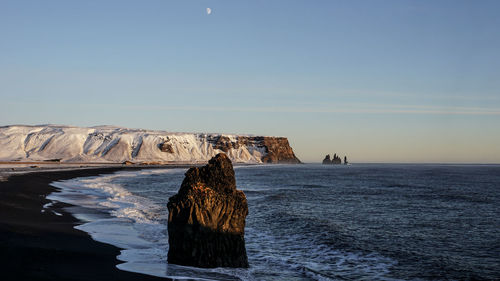 Rock formation in sea against sky