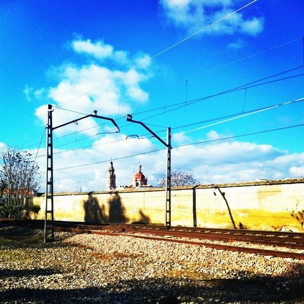 sky, power line, electricity pylon, cloud - sky, cable, cloud, blue, power supply, connection, electricity, transportation, road, power cable, cloudy, railroad track, built structure, landscape, outdoors, day, tree