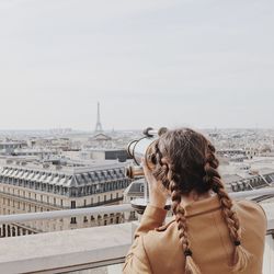 Rear view of woman with cityscape in background