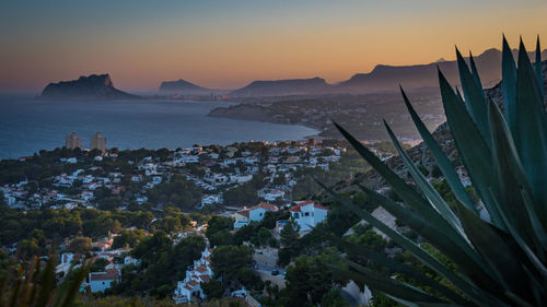 Scenic view of sea and town against sky at sunset