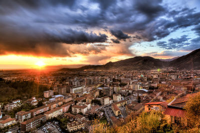 Aerial view of cityscape against dramatic sky