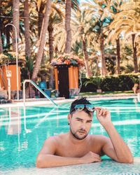 Portrait of handsome man with sunglasses in swimming pool