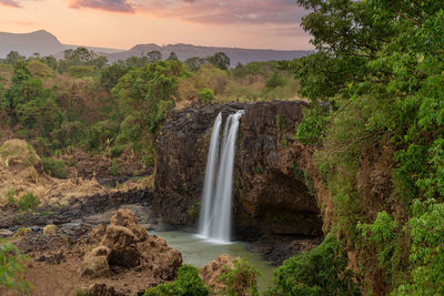 Scenic view of waterfall against sky