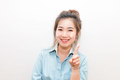 Portrait of smiling young woman against white background