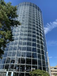 Low angle view of glass building against sky