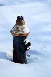 Close-up of rusty fire hydrant on snow covered field