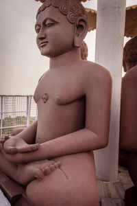 Low angle view of shirtless statue against railing