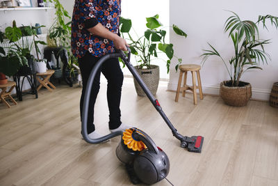 Mature man cleaning with vacuum cleaner at home