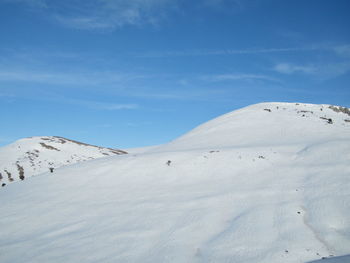 Scenic view of snowcapped mountain against blue sky