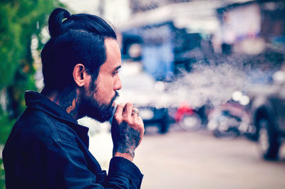 Portrait of young man looking away outdoors