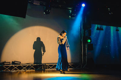 People standing on illuminated stage at night