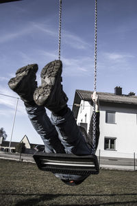 Full length of boy on swing against house