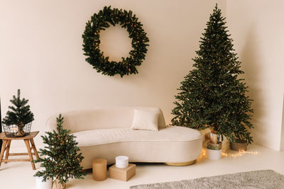 Christmas festive interior of a decorated cozy living room with a sofa at home