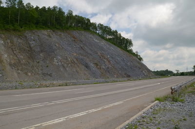 Empty road by land against sky