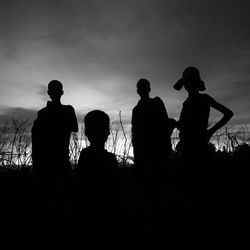 Silhouette people standing against sky during sunset