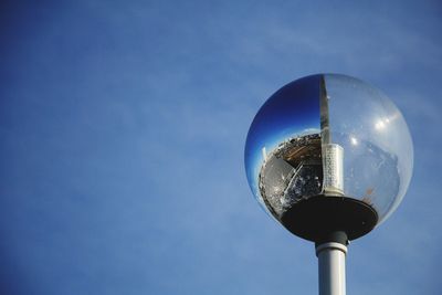 Low angle view of street light against blue sky