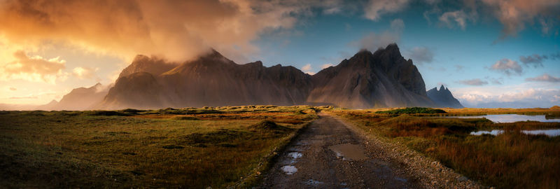 Panoramic view of mountains against dramatic sky during sunset