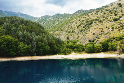 Scenic view of lake and mountains against sky