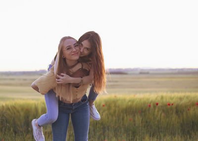 Two women holding hands at sunset in the field