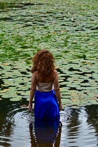 Rear view of woman standing in lake