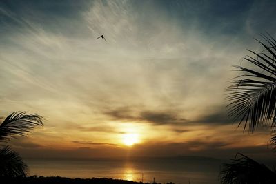 Scenic view of sea against cloudy sky during sunset