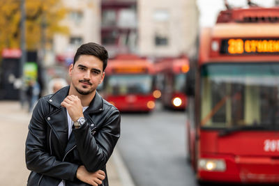 Image of handsome young man walking on the street and looking at camera.