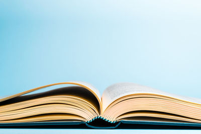 Close-up of open book on table against blue background