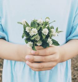 Midsection of woman holding bouquet of flowers