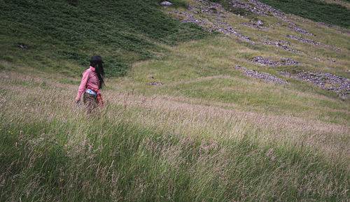 Rear view of person walking on field