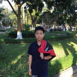 Portrait of boy standing against trees