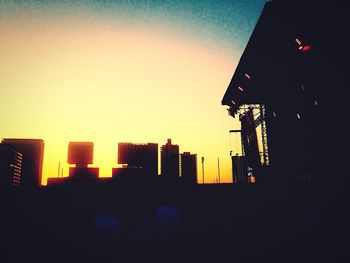 Silhouette buildings against sky during sunset