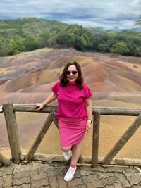 Portrait of young woman standing against mountain