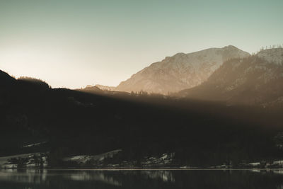 Scenic view of lake and mountains against clear sky