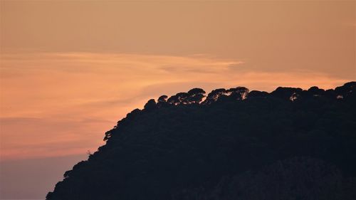 Silhouette rocks against sky during sunset