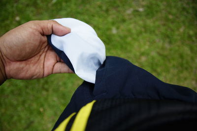 Midsection of person holding umbrella on field