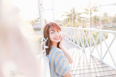 Portrait of young woman standing against wall