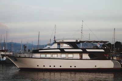 Boats moored at harbor against sky