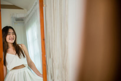 Portrait of young woman standing at home