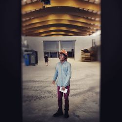 Full length portrait of man standing in building