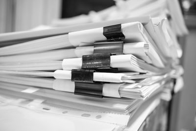 Close-up of binder clips on papers over table