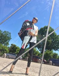 Low angle view of boy wearing sunglasses against sky