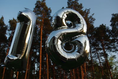 Low angle view of balloon numbers against sky