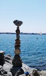 Stack of rocks on beach against clear sky