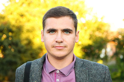 Millennial man, 20-29 years old, walking in nature during autumn, close-up portrait. blurred summer 