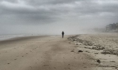 Scenic view of beach against cloudy sky
